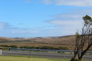 una carretera en medio de un campo con colinas en 12 Apostles Cottages, en Princetown