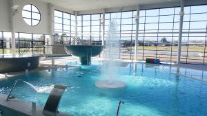 a large swimming pool with a fountain in a building at Pension Casa Pinilla in Cascante