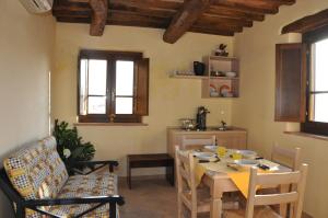 a living room with a table and chairs and a kitchen at Agriturismo La Casella in San Terenziano