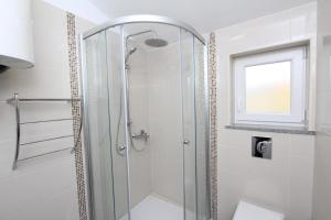 W łazience znajduje się prysznic ze szklanymi drzwiami. w obiekcie Apartments Sorriso w Rovinj +37 zdjęć