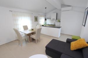 salon z kanapą i stołem oraz kuchnia w obiekcie Apartments Sorriso w Rovinj