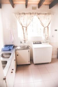 a kitchen with white cabinets and a sink and a window at 29 Polvy Street in Nelspruit