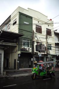 a green golf cart parked in front of a building at Hostel Urby in Bangkok +31 photos