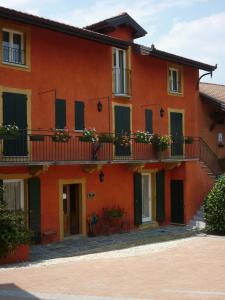 an orange building with balconies and a patio at Locanda la Casetta in Angera