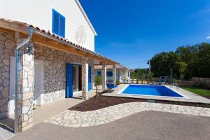 a villa with a swimming pool next to a house at Villa Milohnici Florian in Milohnići