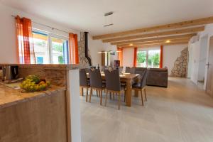 a kitchen and dining room with a table and chairs at Villa Milohnici Florian in Milohnići