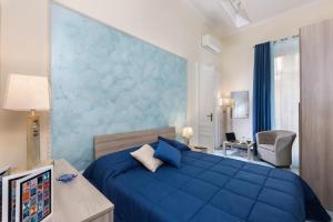 - une chambre avec un lit bleu et un mur bleu dans l'établissement Residenza Santa Lucia a Mare, à Naples