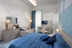 une chambre avec un lit bleu et un salon dans l'établissement Residenza Santa Lucia a Mare, à Naples