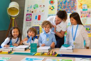 a group of children sitting at a table in a classroom at Hôtel Barrière Le Majestic Cannes in Cannes