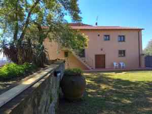 a house with two white chairs in front of it at Agriturismo di Rina in Lamporecchio