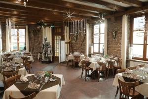 a dining room with tables and chairs and a statue at Hotel Restaurant 3 Châteaux in Ribeauvillé