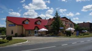 un hotel con techo rojo al lado de una carretera en Motel Za Grosik, en Wałcz