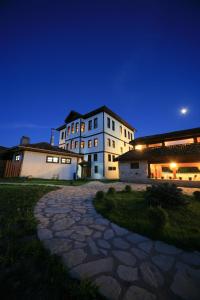 a large white building at night with a stone pathway at Hotel Sadibey Ciftligi in Kasaba