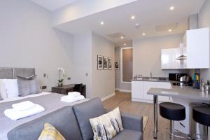 a living room and kitchen with a bed and a table at Nelson Mandela Place Apartments in Glasgow +28 photos