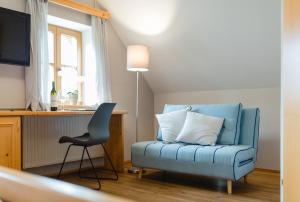 a room with a blue chair and a television at Weingut Schauer in Kitzeck im Sausal