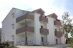 a building with balconies on the side of it at Apartments Tanja & Josipa in Pag