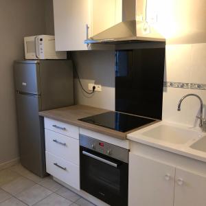 a kitchen with a stove top oven next to a sink at La maison de Julie Albert in Albert