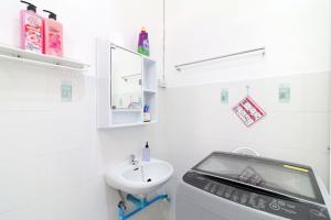 a white bathroom with a sink and a toilet at Chaweng Apartment in Chaweng