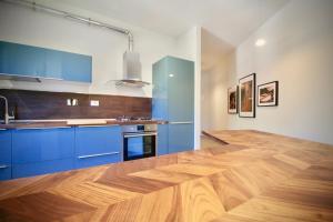 a kitchen with blue cabinets and a wooden floor at Pepe Nero in Bordighera +6 photos