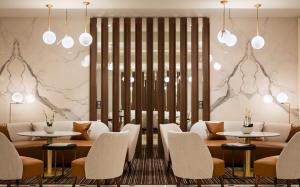 a restaurant with tables and chairs and lights at Hôtel Barrière Le Gray d'Albion in Cannes