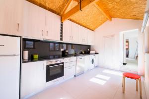 a kitchen with white cabinets and a red stool at Aguda Beach Charming House By PortoProperties4You in Vila Nova de Gaia