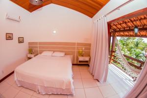 a bedroom with a bed and a large window at Recanto do Barao Pousada in Jericoacoara