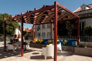 Alfama Terrace في لشبونة: بريغولا خشبي مع أريكة على الفناء