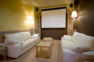 a living room with a white couch and a screen at Hotel Solsona Centre in Solsona