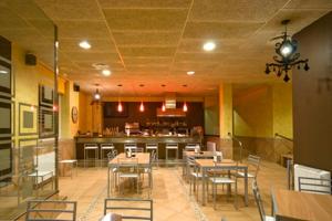 a restaurant with tables and chairs and a bar at Hotel Solsona Centre in Solsona