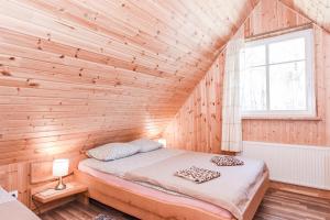 a bedroom with a bed in a wooden wall at Manto Apartamentai in Druskininkai