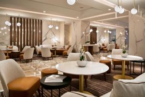 a restaurant with white tables and chairs and tablesktop at Hôtel Barrière Le Gray d'Albion in Cannes