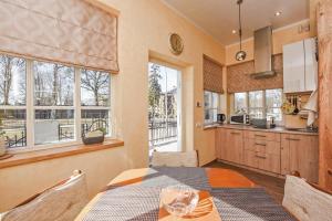 a kitchen with a table and some windows at Manto Apartamentai in Druskininkai