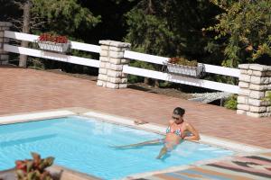 uma mulher numa piscina com um golfinho em Myrto Homes Lefkada Agios Nikitas Greece em Ayios Nikitas