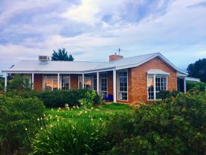 a brick house with a lawn in front of it at Melbourne Garden Bed and Breakfast in Melton