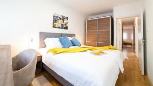 a bedroom with a large bed with a yellow blanket on it at Novel Inn in Belgrade +41 photos