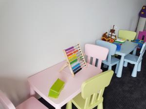 ミコワイキにあるPokoje Wileńskaのピンクのテーブルと椅子が備わる教室