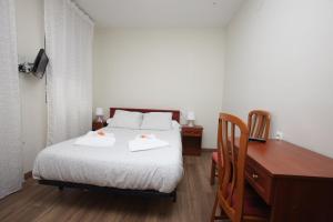 1 dormitorio con 1 cama con 2 toallas en Hostal Restaurante Central en La Virgen del Camino