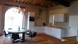 a kitchen with a table and chairs and a dining room at Logies Berckelaer in Sint-Gillis-Waas