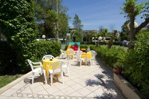 a group of tables and chairs on a patio at Hotel Pigalle in Riccione