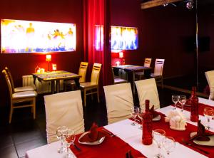 un restaurante con mesas y sillas con manteles rojos en North Crown Hotel, en Víborg