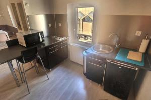 a small kitchen with a sink and a microwave at Le Grandthille in Chalons en Champagne