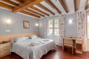 een slaapkamer met een groot bed en een bureau bij Hotel La Terraza De Puente Viesgo in Puente Viesgo