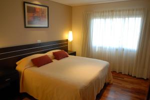 a bedroom with a large white bed with a window at Hotel Ankara Suites in Salta