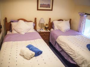 a bedroom with two beds with towels on them at Fehanaugh Cottage in Atadav Bridge