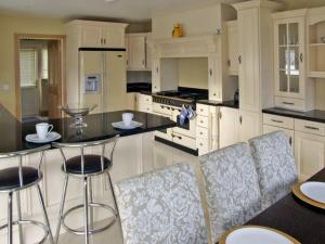 a kitchen with white cabinets and bar stools at River House in Hollywood