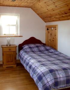 a bedroom with a bed and a window at 1 Clancy Cottages in Kilkieran