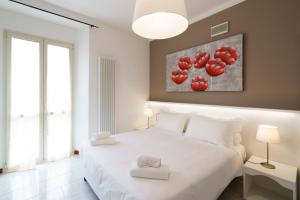 a bedroom with a white bed with red tomatoes on the wall at Residence Riva del Lario in Gravedona