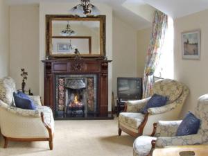 a living room with two chairs and a fireplace at 4 Bell Heights Apartments in Kenmare