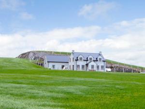 a large house on a grassy hill with a house at Ardagh North in Barloge