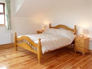 a bedroom with a wooden bed and two night stands at Ardagh North in Barloge